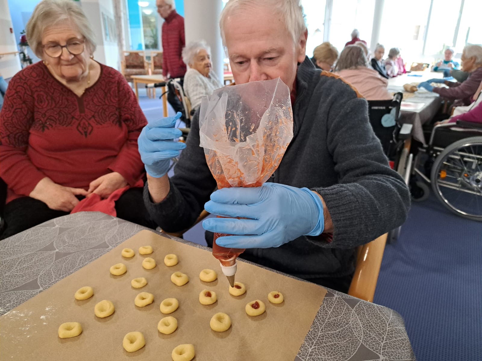 ein Bewohner verziert die Plätzchen mit Marmelade