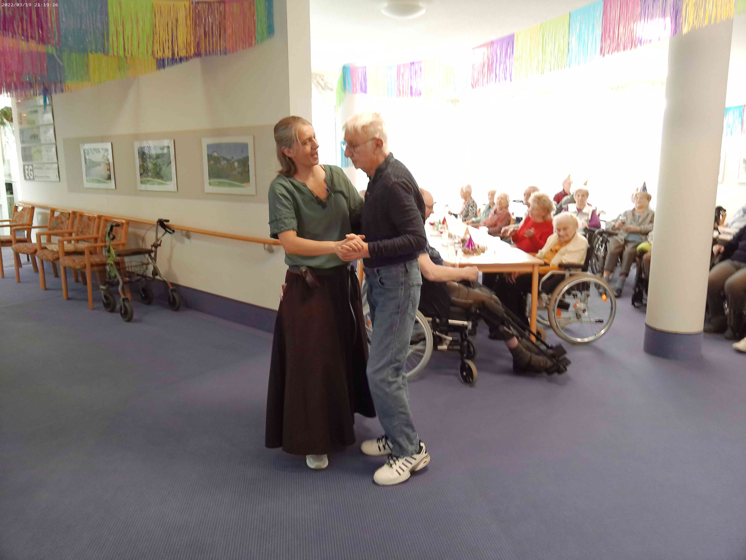 ein Bewohner tanzt mit einer Mitarbeiterin