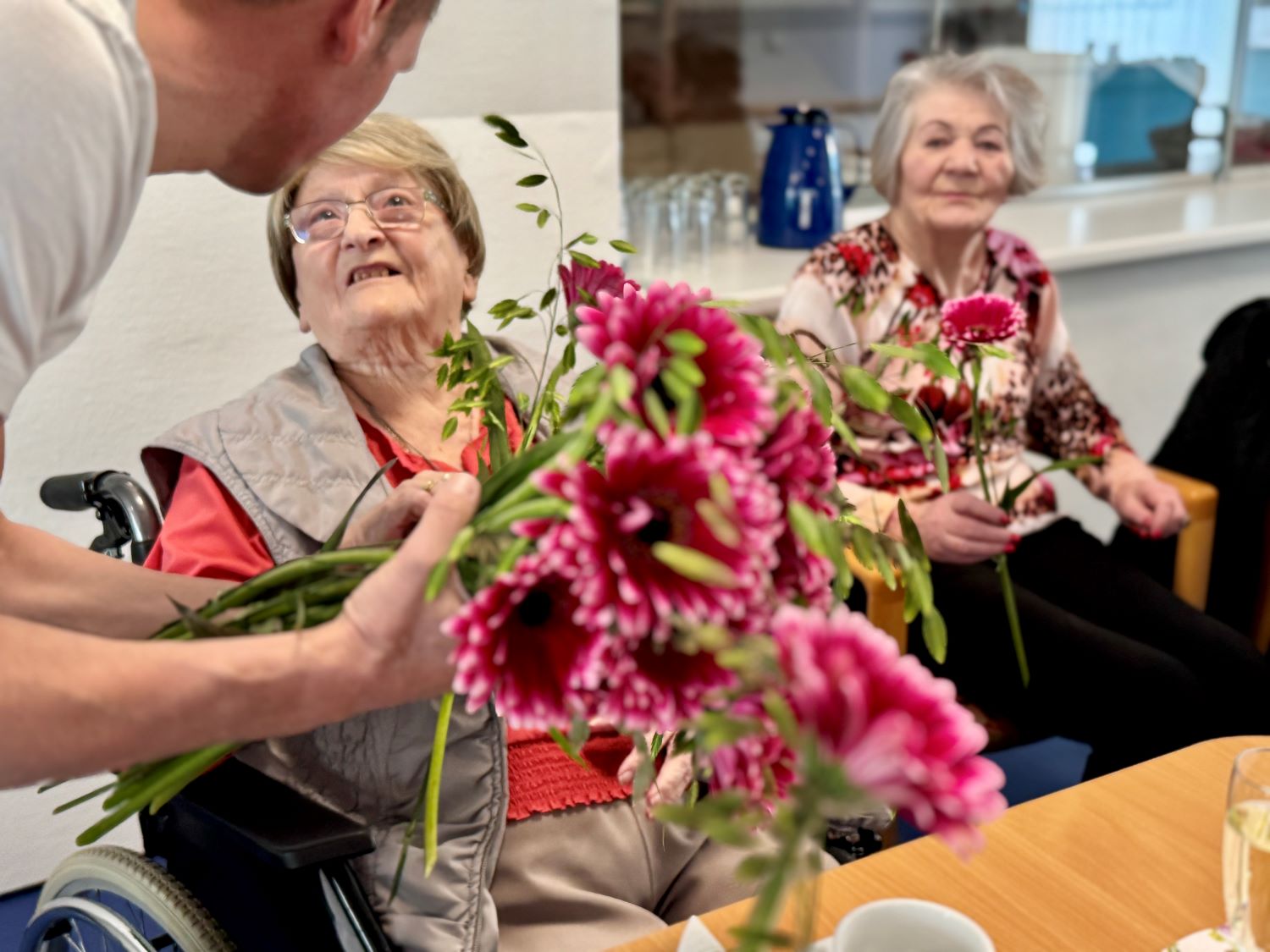 die Bewohnerinnen bekommen jeweils eine Blume überreicht